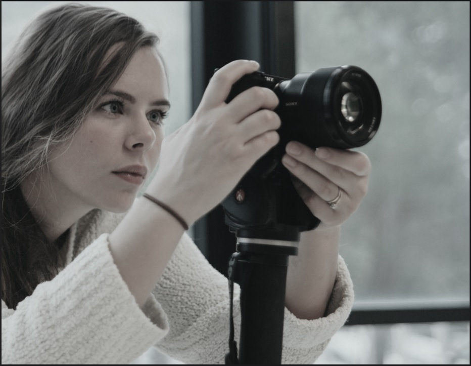 A young woman filming with a camera on a tripod